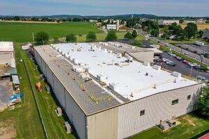 Aerial view of commercial building roof showcasing roofing materials and Conklin roofing systems.